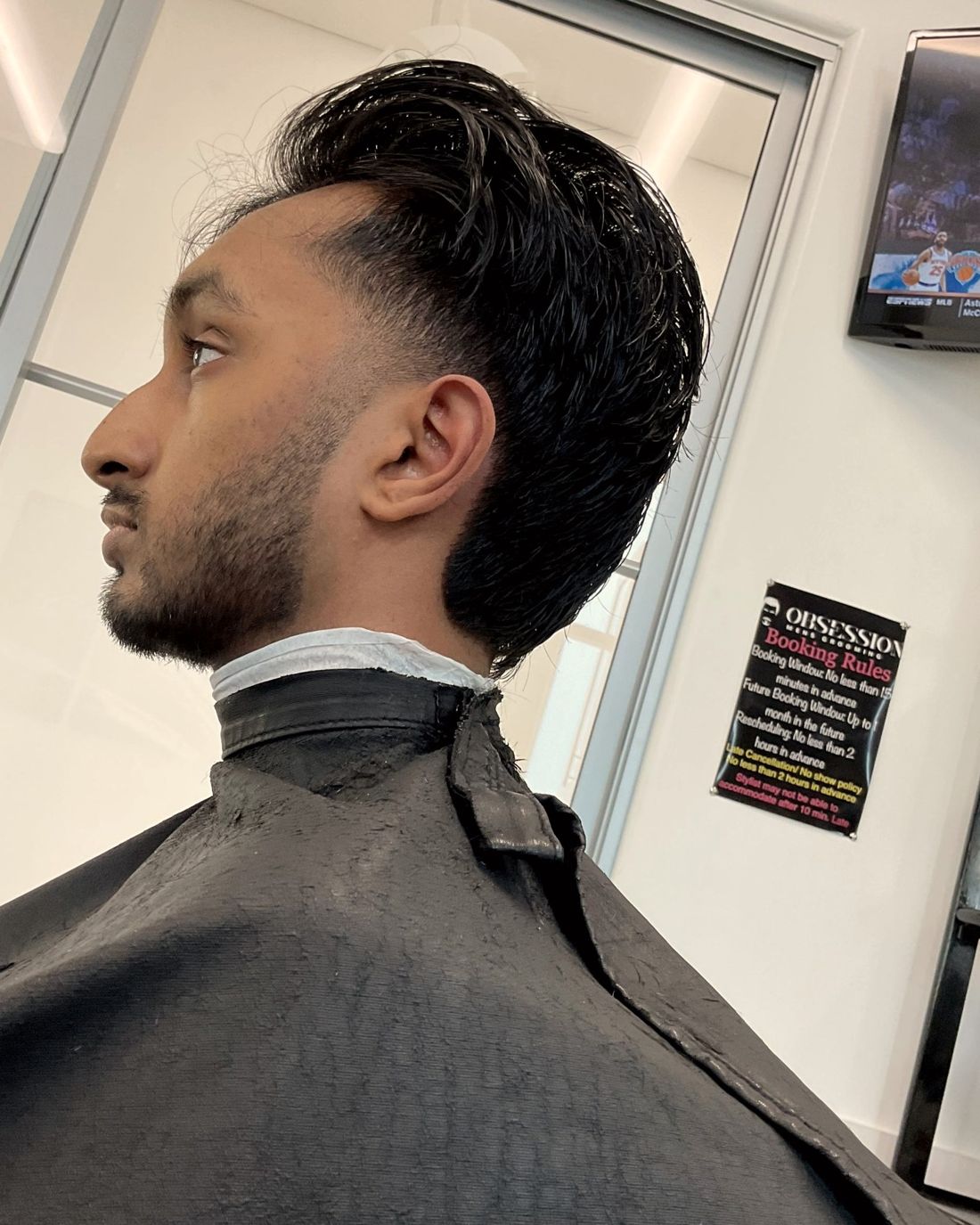 Swept-back cut with tapered sides and trimmed beard