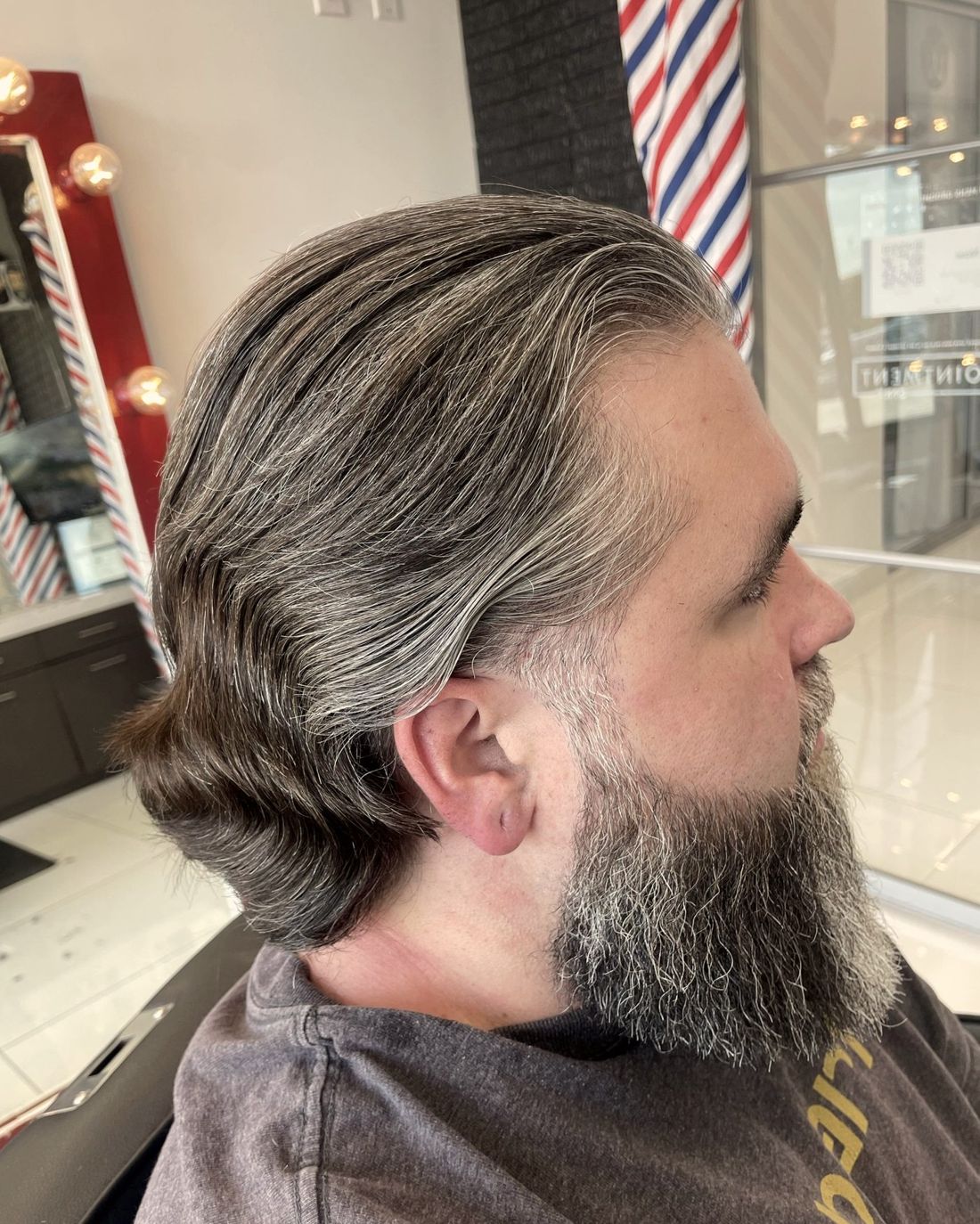 Long grey hair shaped with a full beard
